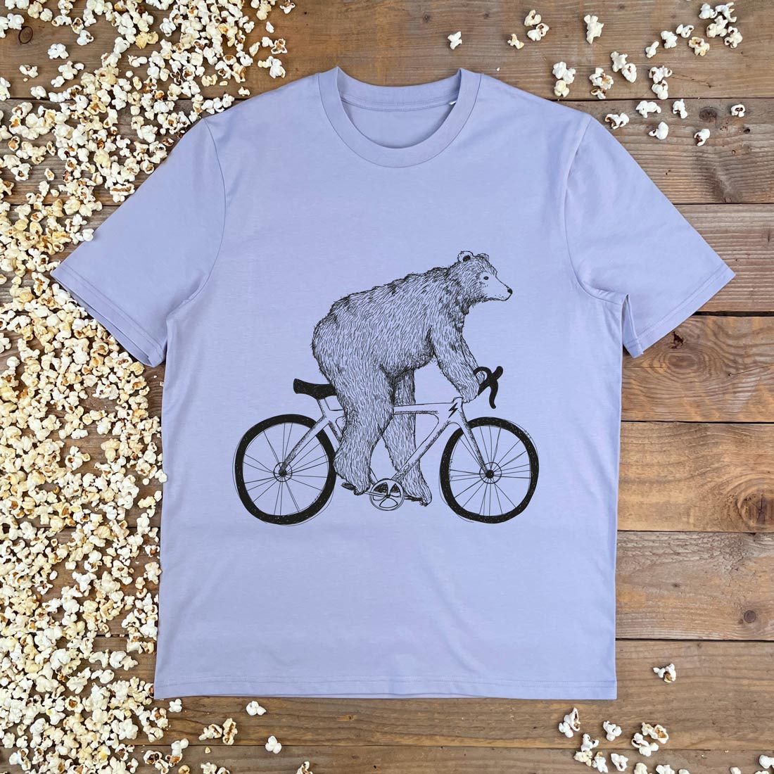 bear riding a racer bike on lilac tshirt