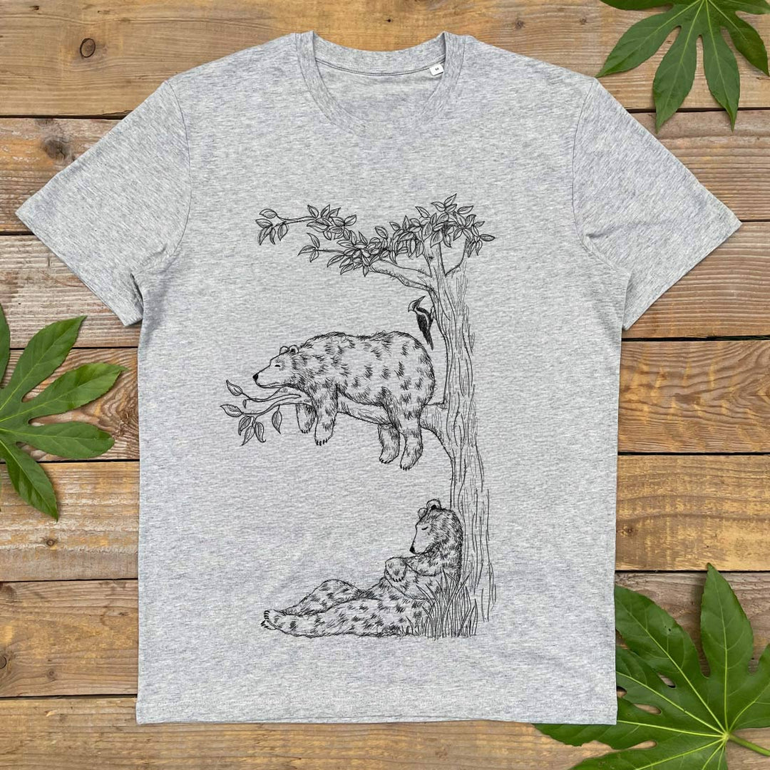 Gray t-shirt with bear illustration on a wooden surface with leaves